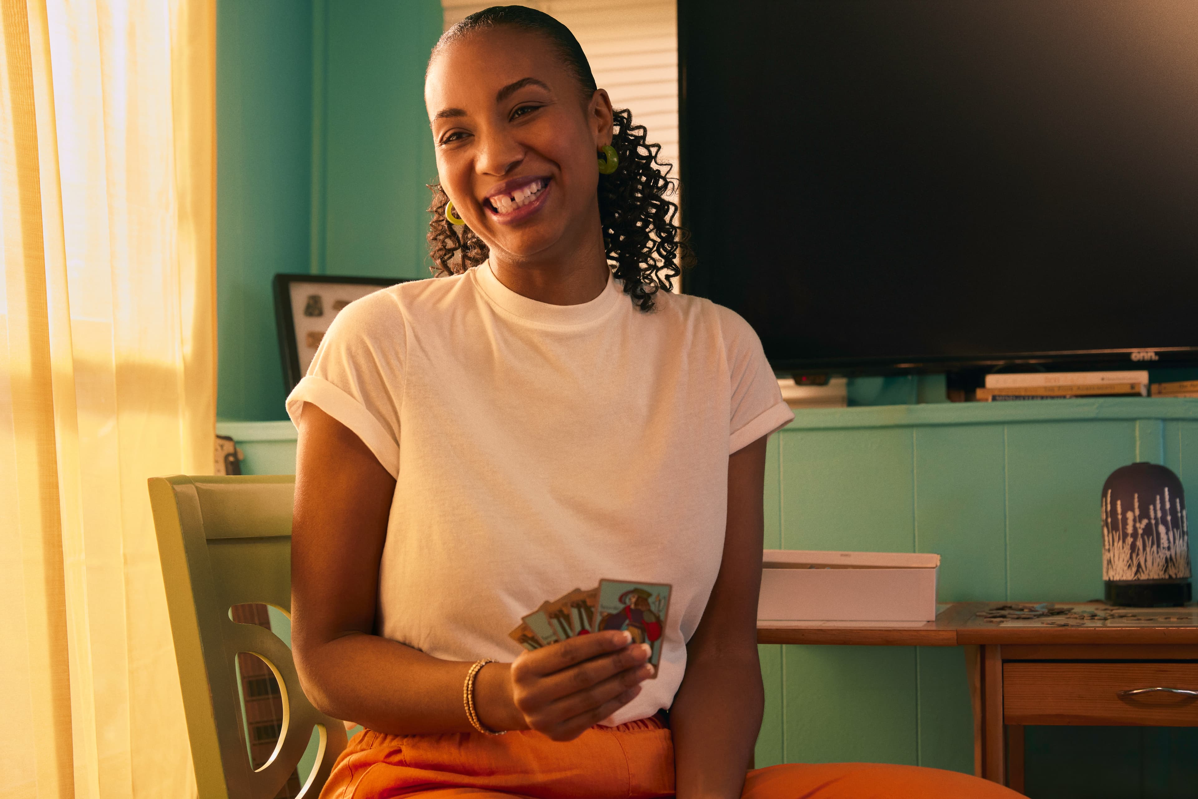 A smiling woman playing cards